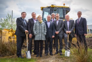 Image of dignitaries in front of a stationary bulldozer at Kingsway Business Park